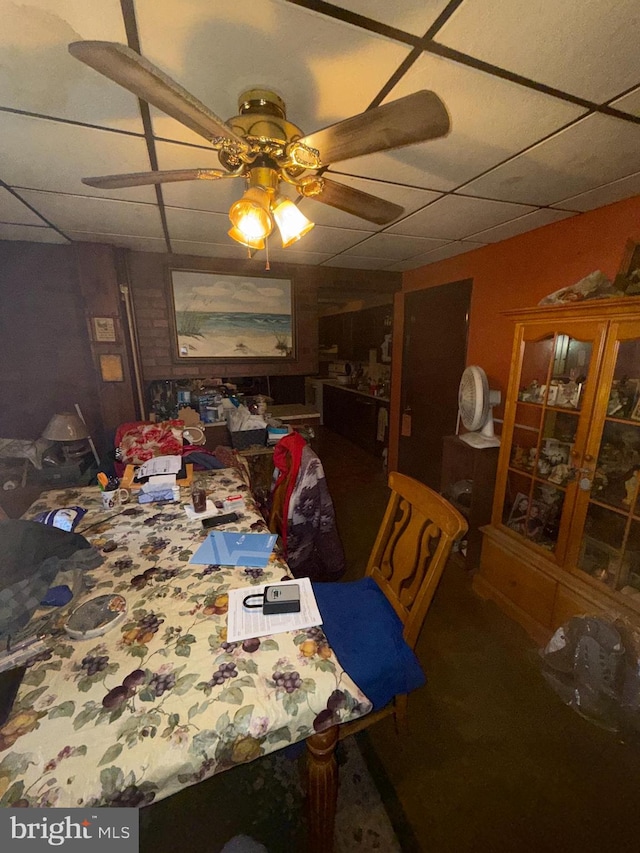 dining space featuring a drop ceiling and ceiling fan