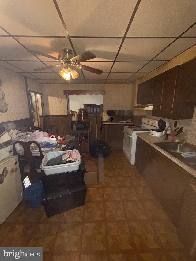 kitchen with a paneled ceiling, dark brown cabinetry, white electric range, and ceiling fan