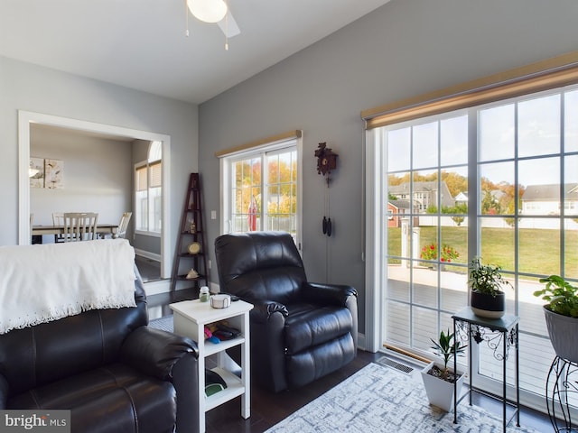 living room with ceiling fan and dark hardwood / wood-style flooring