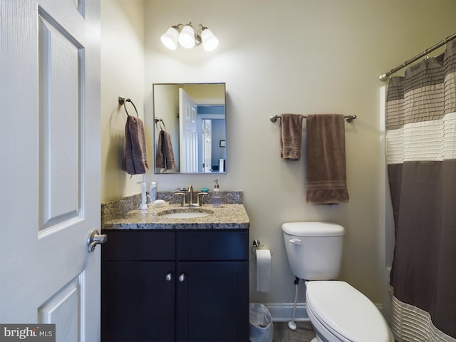 bathroom featuring toilet, vanity, and a shower with shower curtain