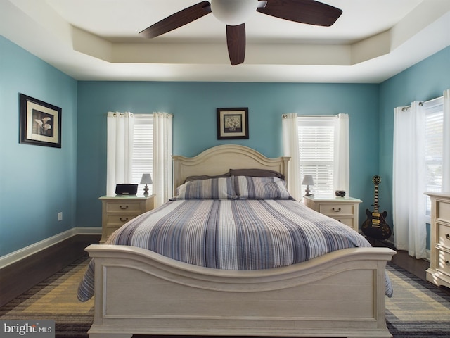 bedroom with multiple windows, dark wood-type flooring, and ceiling fan