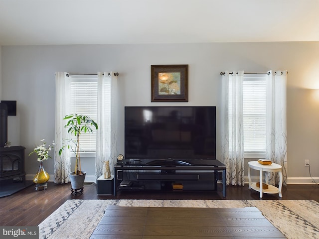 living room with dark wood-type flooring and a wood stove