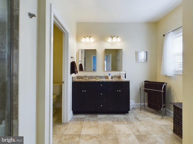 bathroom featuring vanity, toilet, and a shower with shower door