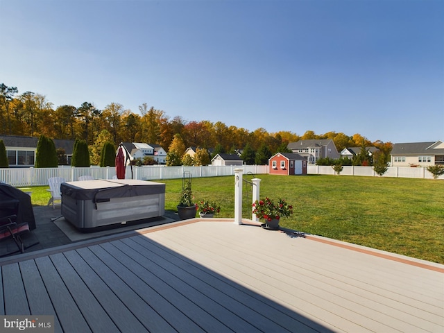 wooden deck with a yard, a hot tub, and a shed