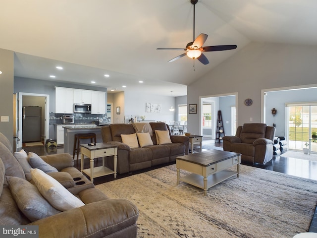 living room featuring ceiling fan, high vaulted ceiling, and dark hardwood / wood-style floors