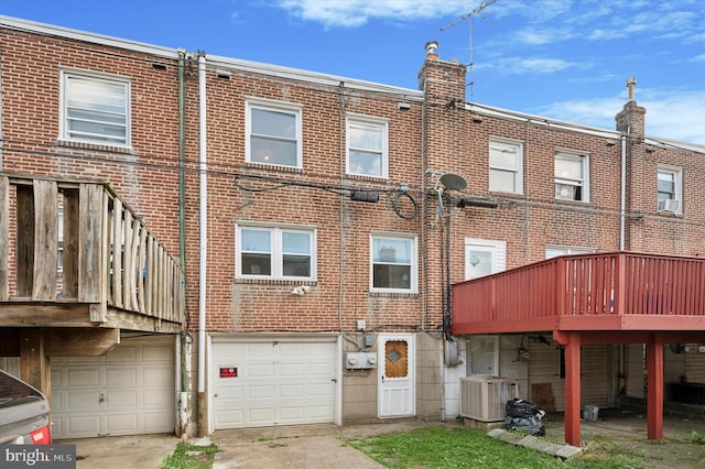 back of house featuring a wooden deck, a garage, and cooling unit