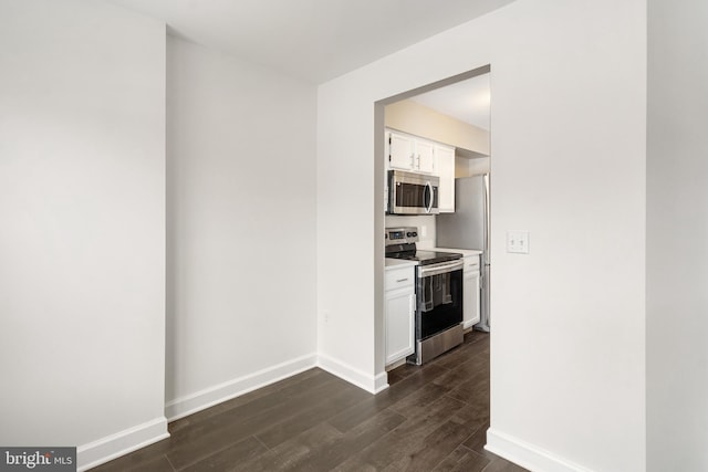 kitchen featuring stainless steel appliances, white cabinetry, and dark hardwood / wood-style floors