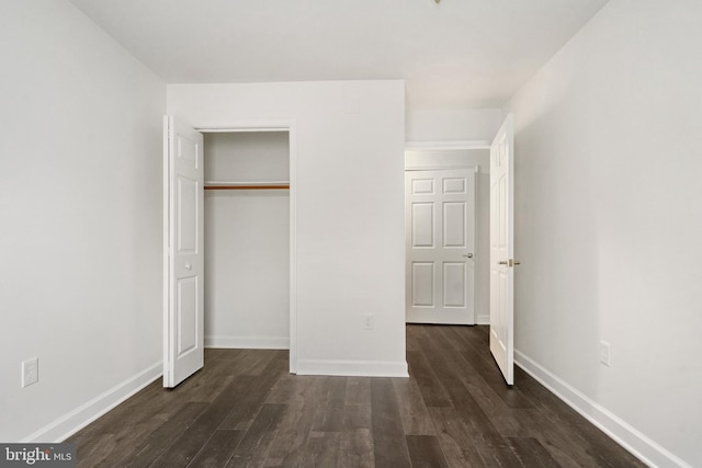 unfurnished bedroom featuring dark hardwood / wood-style flooring and a closet