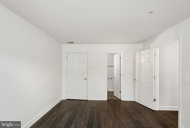 unfurnished bedroom with dark wood-type flooring