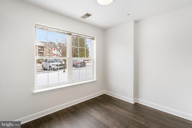 unfurnished room with dark wood-type flooring