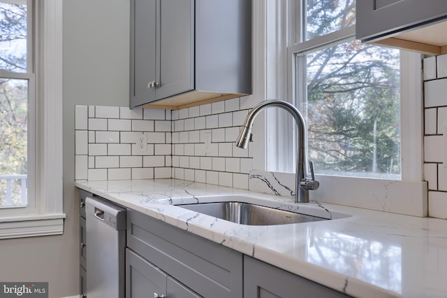 kitchen featuring gray cabinets, sink, dishwasher, and a healthy amount of sunlight