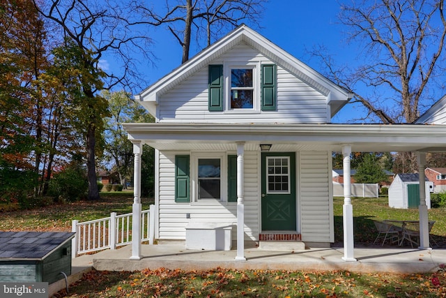 bungalow featuring a shed and a porch