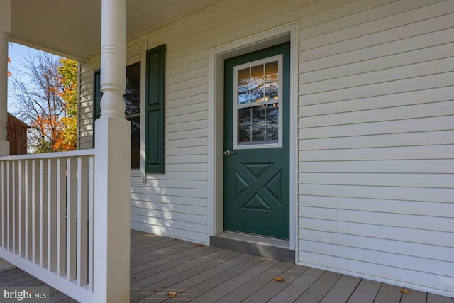 view of exterior entry featuring covered porch