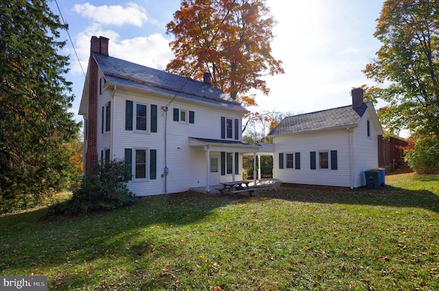 back of house with a patio area and a lawn