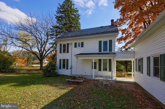 rear view of property featuring a yard and a patio area