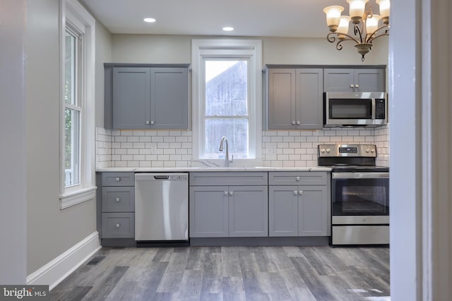 kitchen featuring hardwood / wood-style floors, sink, stainless steel appliances, and a healthy amount of sunlight