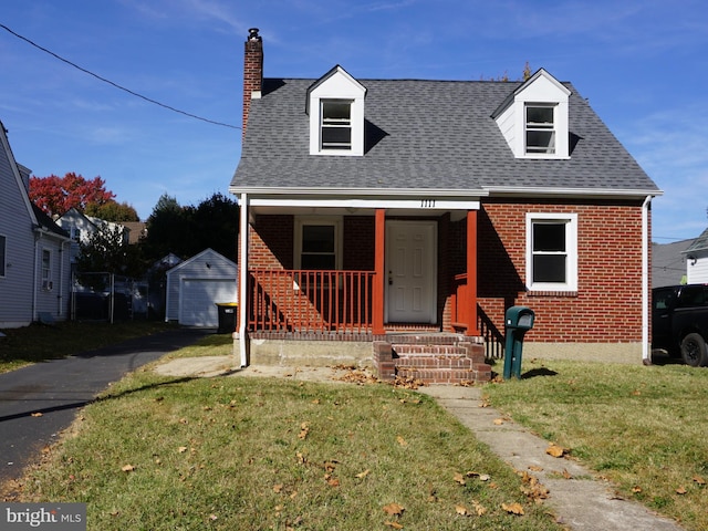 new england style home with a front yard and a porch