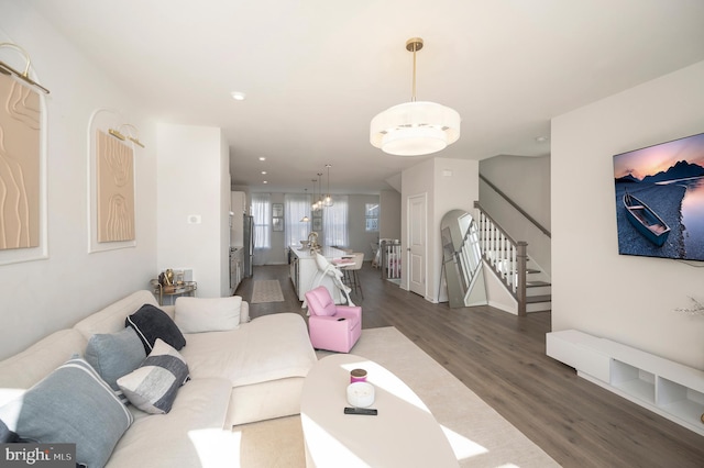 living room featuring a chandelier and dark wood-type flooring