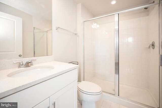 bathroom with toilet, walk in shower, vanity, and tile patterned floors