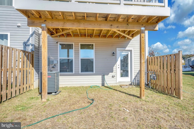 back of property featuring cooling unit and a lawn