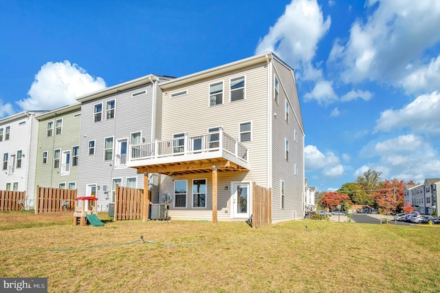 rear view of property featuring a yard and cooling unit