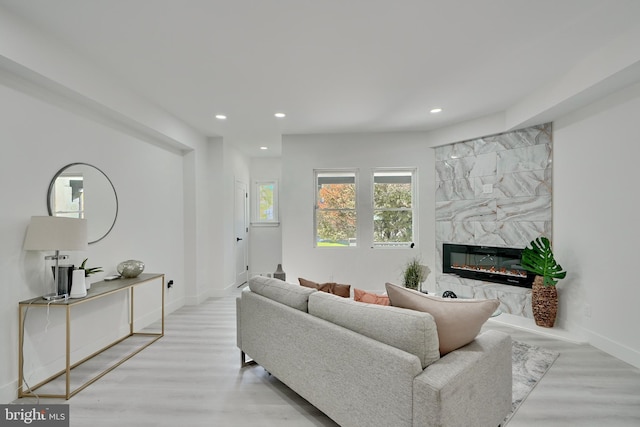 living room featuring light hardwood / wood-style flooring and a high end fireplace