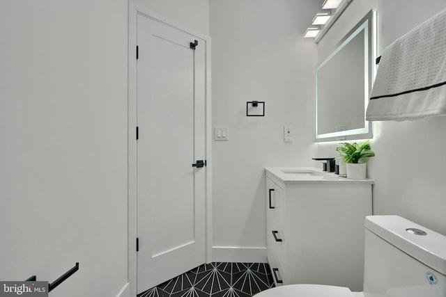 bathroom with vanity, toilet, and tile patterned floors