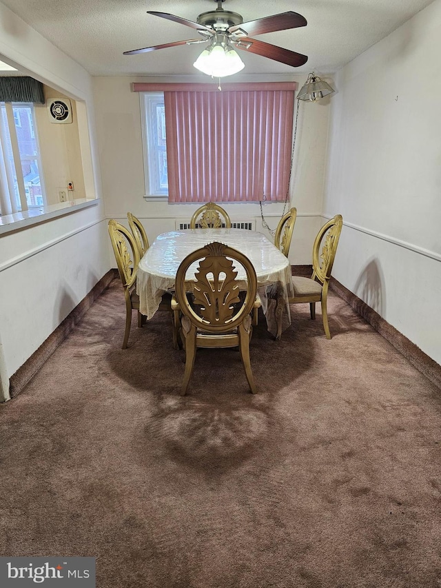 dining space featuring a textured ceiling, ceiling fan, and carpet floors