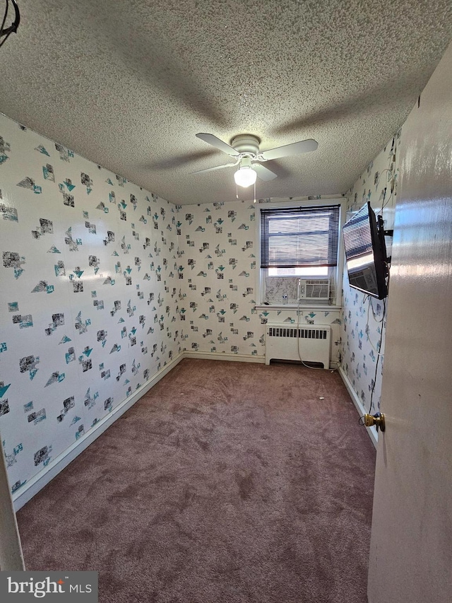 spare room with radiator, cooling unit, carpet, a textured ceiling, and ceiling fan