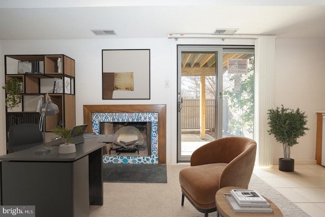 living area featuring light tile patterned floors and a fireplace