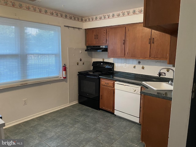 kitchen featuring sink, backsplash, white dishwasher, dark tile patterned floors, and black / electric stove