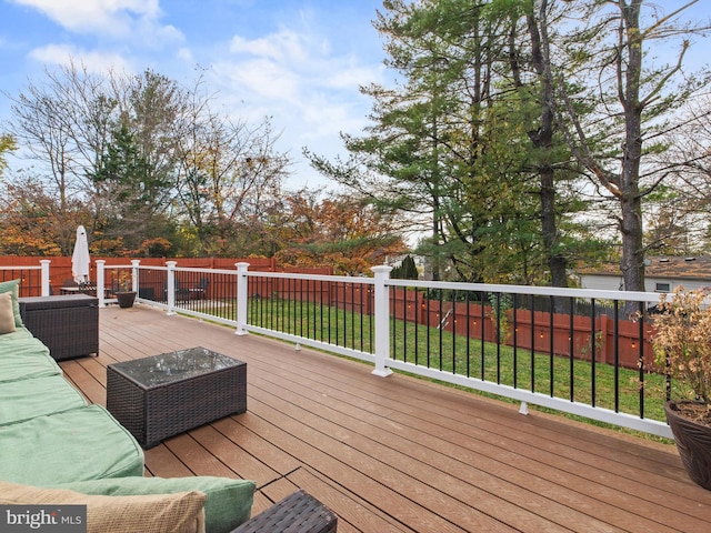 wooden deck featuring outdoor lounge area and a lawn