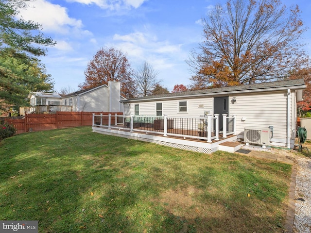 back of property with ac unit, a yard, and a deck