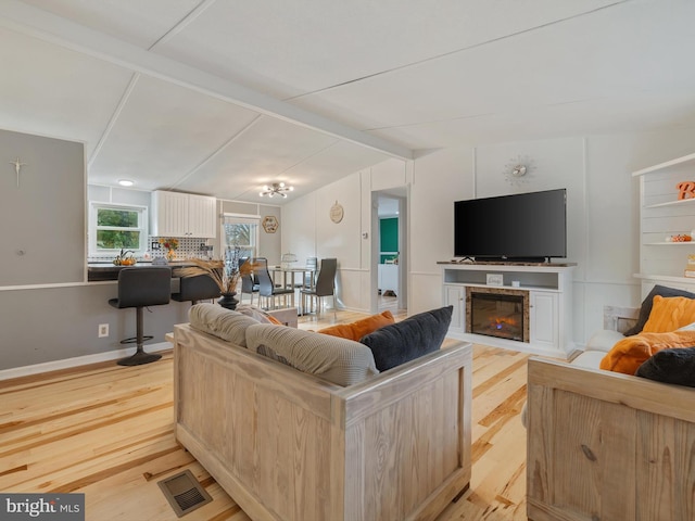 living room featuring lofted ceiling and light hardwood / wood-style floors