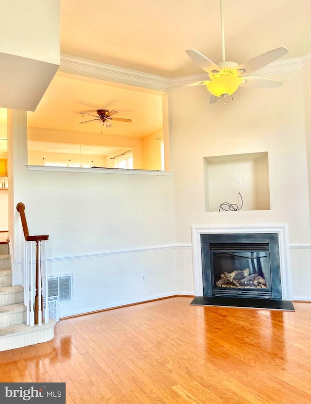 unfurnished living room with ceiling fan, hardwood / wood-style floors, and ornamental molding