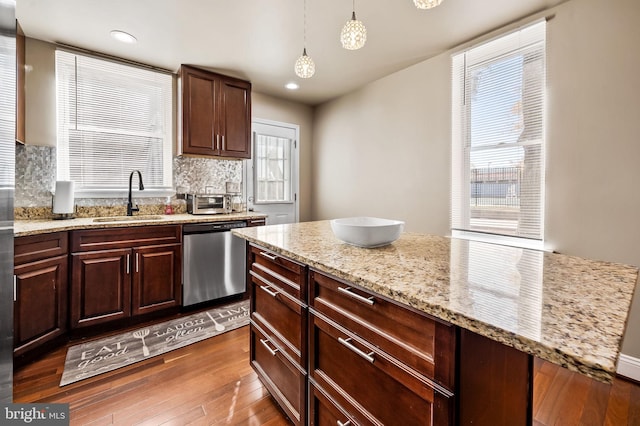 kitchen featuring sink, dishwasher, a wealth of natural light, and hanging light fixtures