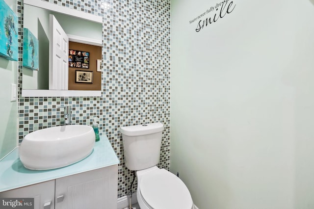 bathroom with backsplash, vanity, toilet, and tile walls