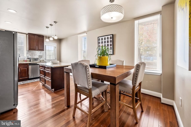 dining area featuring dark wood-type flooring and plenty of natural light