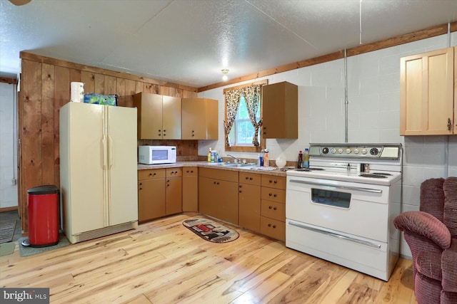 kitchen with white appliances, sink, and light wood-type flooring