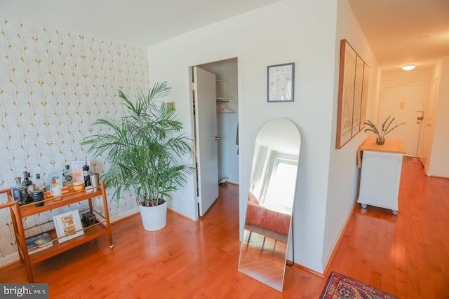 hallway featuring wood finished floors and baseboards