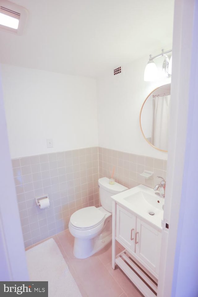 bathroom featuring tile walls, toilet, vanity, and tile patterned floors