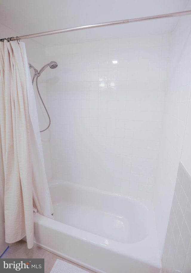 bathroom with shower / bath combo with shower curtain and tile patterned flooring