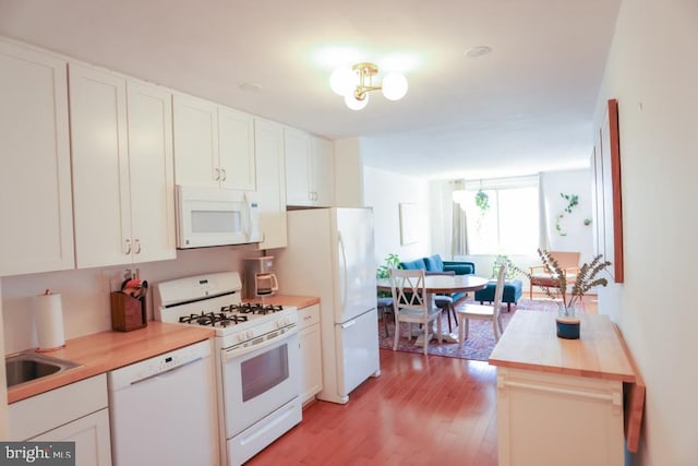 kitchen featuring white appliances, light wood-style floors, white cabinetry, and light countertops