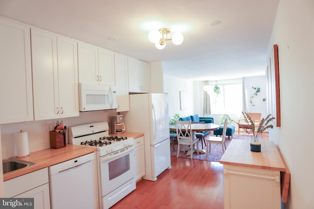 kitchen with wooden counters, light wood-type flooring, white appliances, and white cabinets