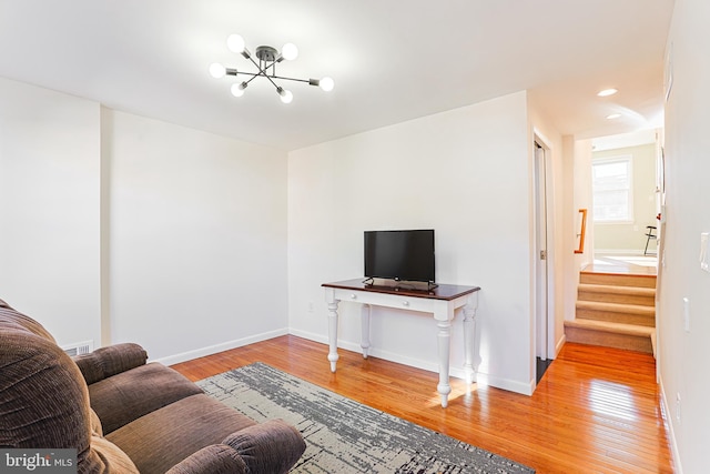 living room with hardwood / wood-style floors and a chandelier