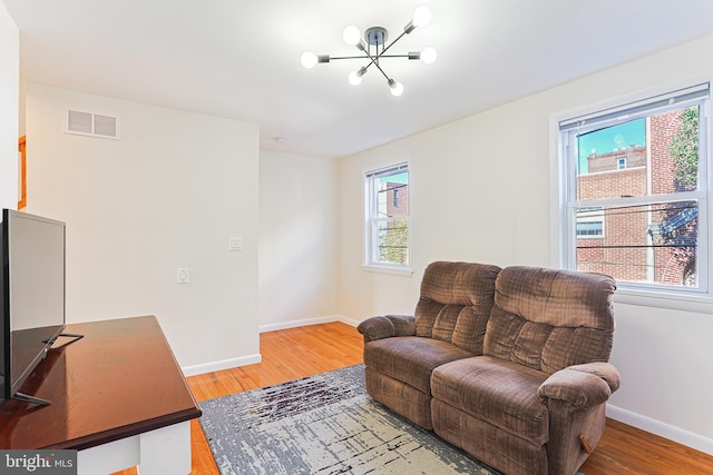 sitting room with a chandelier and wood-type flooring