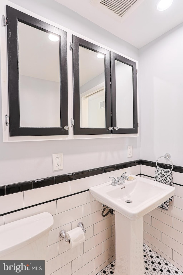 bathroom with tile walls and toilet