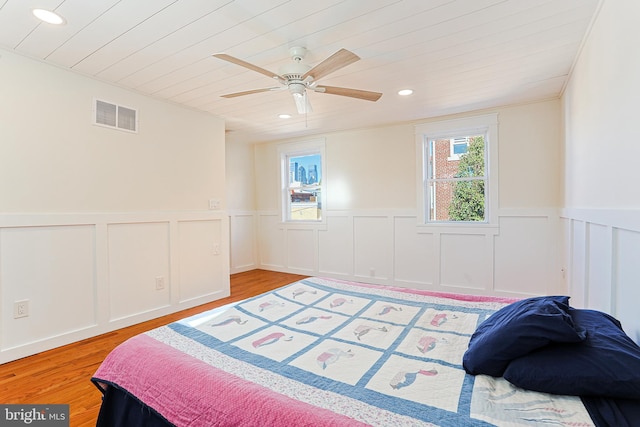 bedroom with light hardwood / wood-style floors, ceiling fan, and crown molding