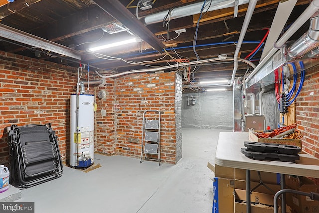 basement featuring gas water heater and brick wall