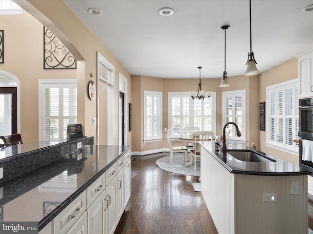 kitchen with white cabinetry, sink, plenty of natural light, and hanging light fixtures